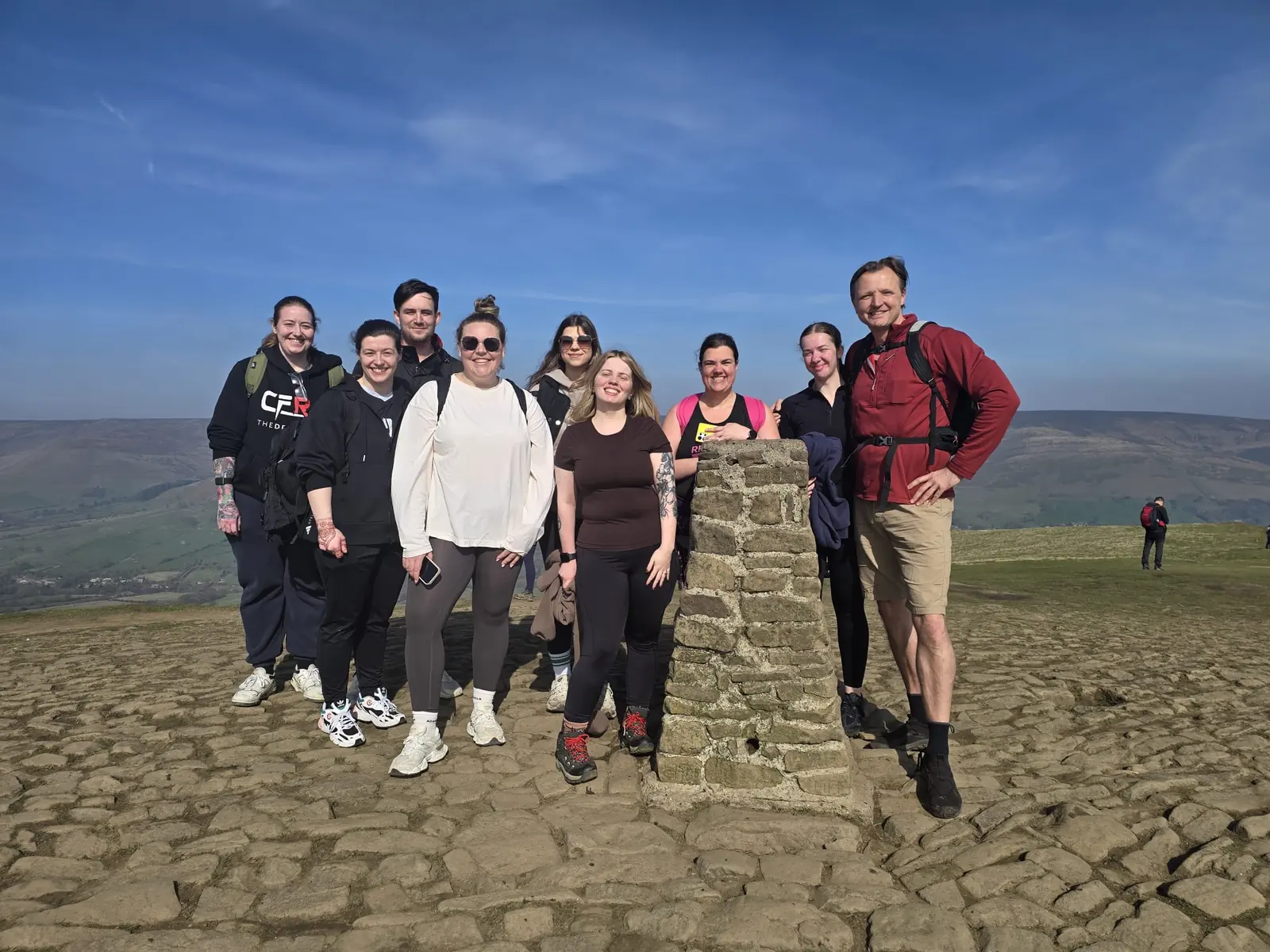 Lycan Strength members at a trig point on a hill walk
